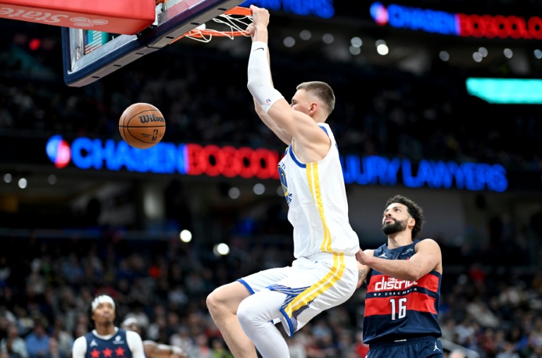 Kristaps Porzingis marque un panier malgré Anthony Gill (d) lors du match NBA des Golden State Warriors contre les Washington Wizards, le 16 mars 2026 à Washington