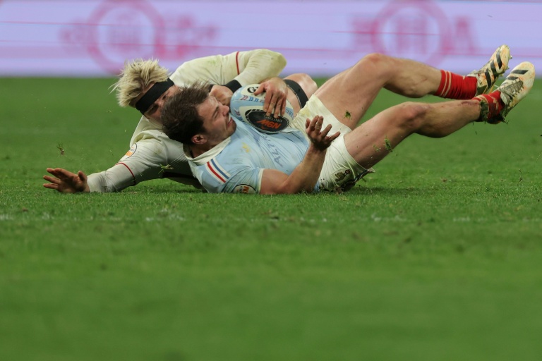 Le demi de mêlée français Antoine Dupont (à droite) est plaqué par le numéro 8 anglais Henry Pollock (à gauche) lors du match du Tournoi des six nations opposant la France à l'Angleterre au Stade de France, le 14 mars 2026