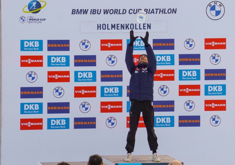 Eric Perrot célèbre sa victoire en coupe du monde en lançant en l'air son gros globe de cristal, dimanche à  Holmenkollen en Norvège.