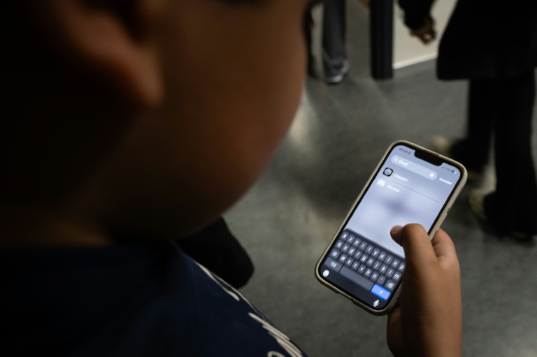 Un élève consulte l'application ChatGPT sur son téléphone après un cours d'intelligence artificielle (IA) au collège Jean Mace à Mulhouse, le 26 mars 2026 dans le Haut-Rhin