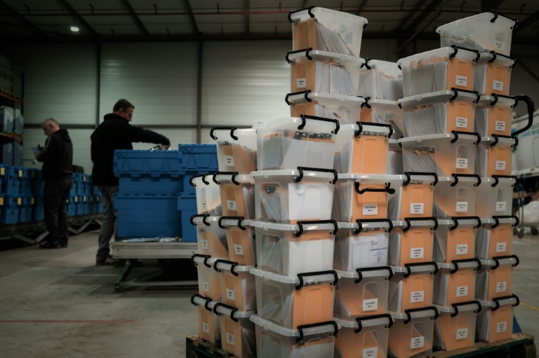 Des cartons contenant des cartes d'électeur non distribuées en attente d'expédition, dans un entrepôt municipal de Bruges, près de Bordeaux, le 12 mars 2026