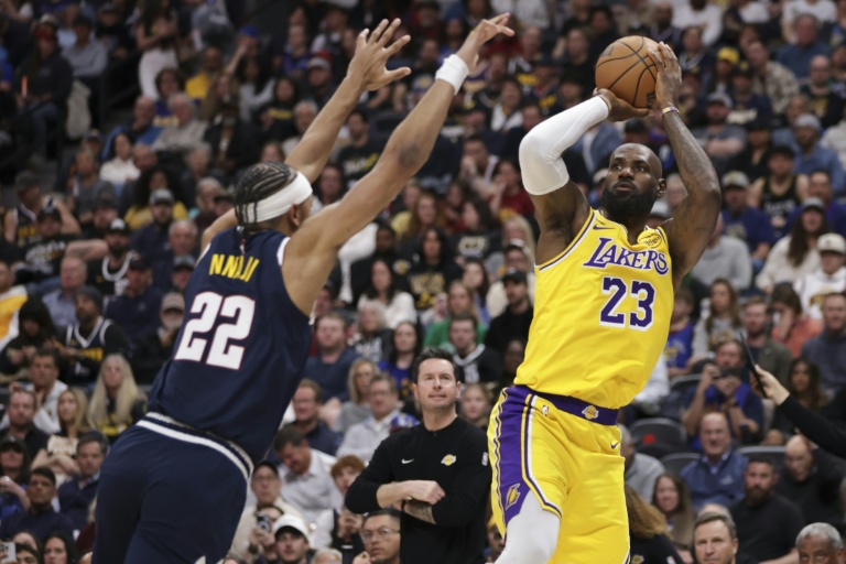 LeBron James (d) tire et marque lors de la première période du match des Los Angeles Lakers contre les Denver Nuggets le 5 mars 2026 à Denver, pour battre le record de paniers marqués en saison régulière de NBA
