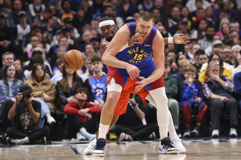 Shai Gilgeous-Alexander (g.), le meneur canadien du Thunder d'Oklahoma City, intercepte la balle devant Nikola Jokic (d.), le pivot serbe des Denver Nuggets au cours d'une rencontre de NBA, à Denver, le 1er février 2026