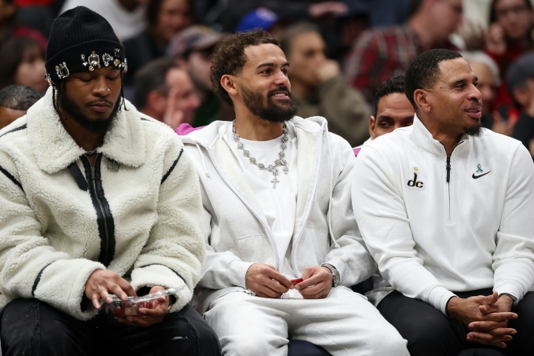 Trae Young (c.), le meneur des Washington Wizards, regarde le match de NBA de son équipe contre les Houston Rockets depuis le banc en tenue de ville, à Washington, le 2 mars 2026