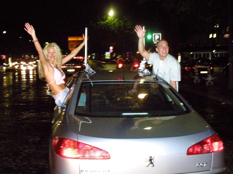Les deux gagnants, Loana (g) et Christophe, roulent sur l'avenue de la Grande Armée à Paris après avoir quitté le loft, le 5 juillet 2001, à l'issue de la soirée finale de Loft Story diffusé sur la chaîne M6
