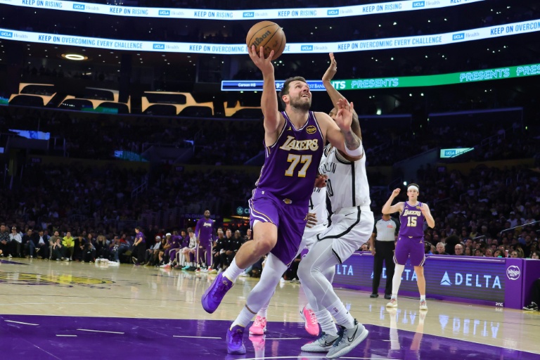 Luka Doncic (g.), le meneur slovène des Lakers de Los Angeles, s'élance pour marquer un lay-up devant Ochai Agbaji (d.), l'arrière des Nets de Brooklyn, lors d'un match de NBA, à Los Angeles, le 27 mars 2026