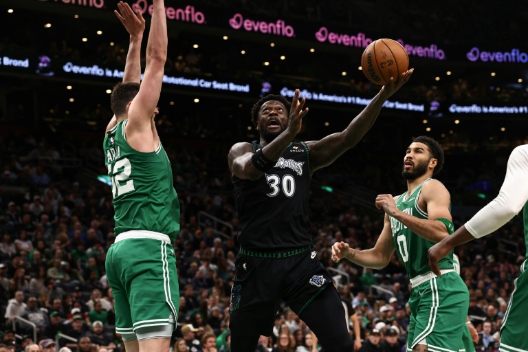Julius Randle tente un tir malgré Luka Garza (g) lors du match NBA des Minnesota Timberwolves contre les Boston Celtics, le 22 mars 2026 à Boston