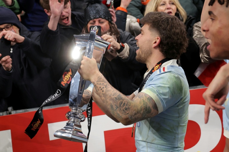 L'ouvreur du XV de France Matthieu Jalibert brandit le trophée après la victoire de son équipe qui remporte son deuxième Tournoi des six nations d'affilée après sa victoire sur le fil contre l'Angleterre samedi soir au Stade de France