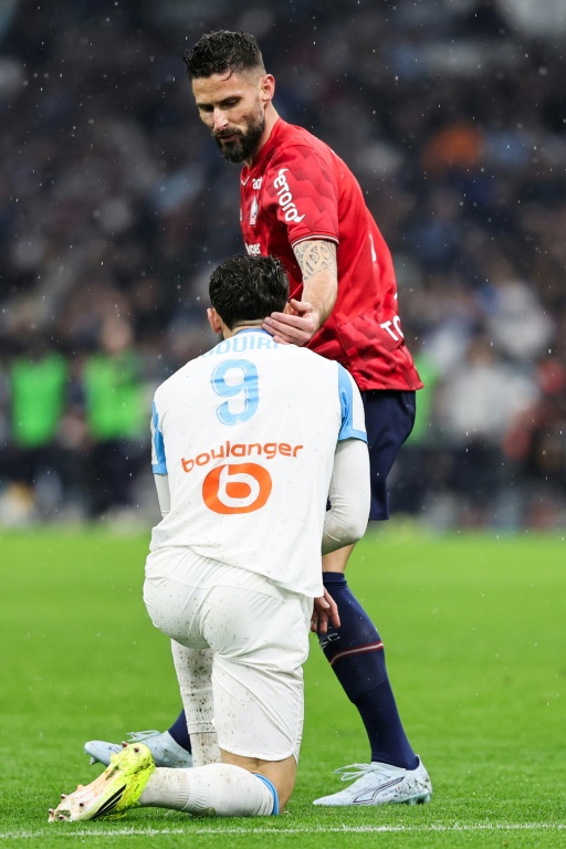 Olivier Giroud (C-D) semble consoler le Marseillais Amine Gouiri après la victoire des Lillois à Marseille (2-1), le 22 mars 2026 au Vélodrome