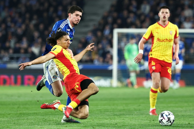 Le défenseur de Lens Ismaelo Ganiou à la lutte contre le Strasbourgeois Joaquin Panichelli (en bleu) lors du match de L1 vendredi au Stade de la Meinau à Strasbourg.