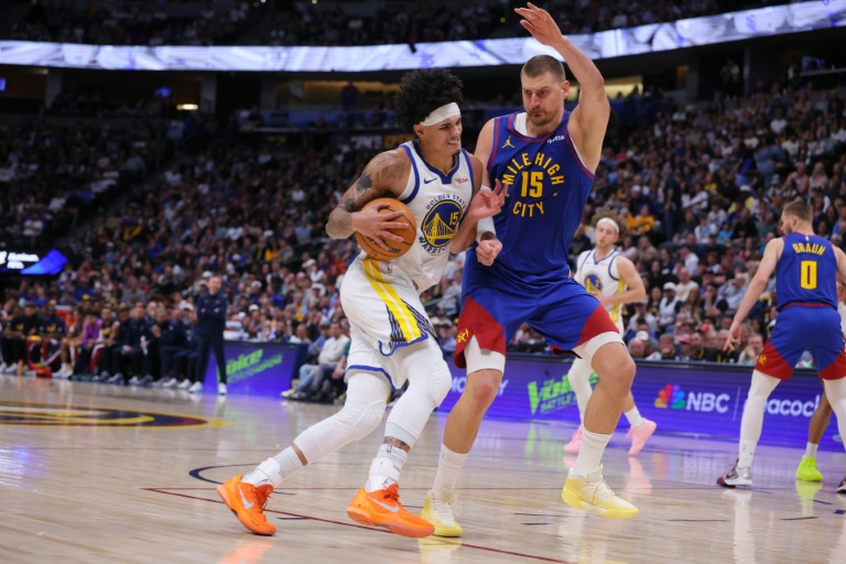 Nikola Jokic (d) défend face à Gui Santos lors du match NBA des Denver Nuggets contre les Golden State Warriors, le 29 mars 2026 à Denver