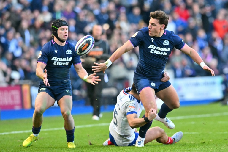 L'Ecossais Tom Jordan (à droite) passe la balle à son coéquipier Darcy Graham malgré un plaquage français, le 7 mars 2026 à Edimbourg lors du Tournoi des six nations
