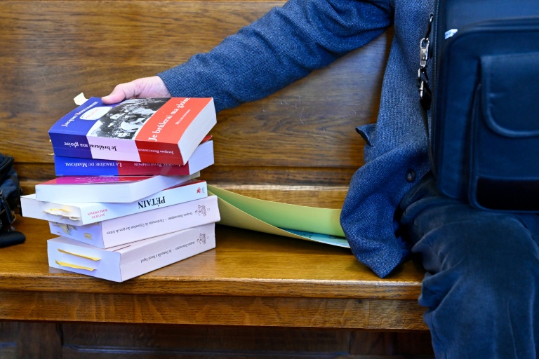 Une pile de livres à côté de Jacques Boncompain, président de l'Association pour défendre la mémoire du Maréchal Pétain (ADMP) lors de son procès devant le tribunal correctionnel de Verdun, le 4 mars 2026 dans la Meuse