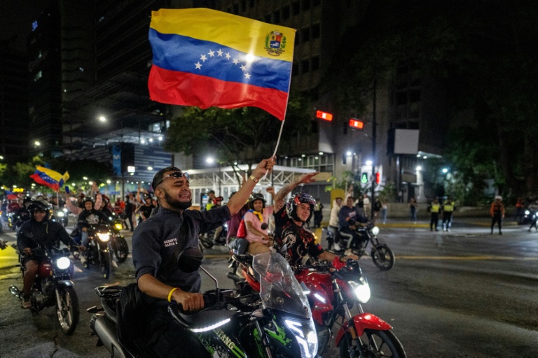 Un fan vénézuélien agite un drapeau national en célébrant la victoire de son équipe nationale de baseball en finale de la la Classique mondiale de baseball contre l’équipe des États-Unis, à Caracas, le 17 mars 2026