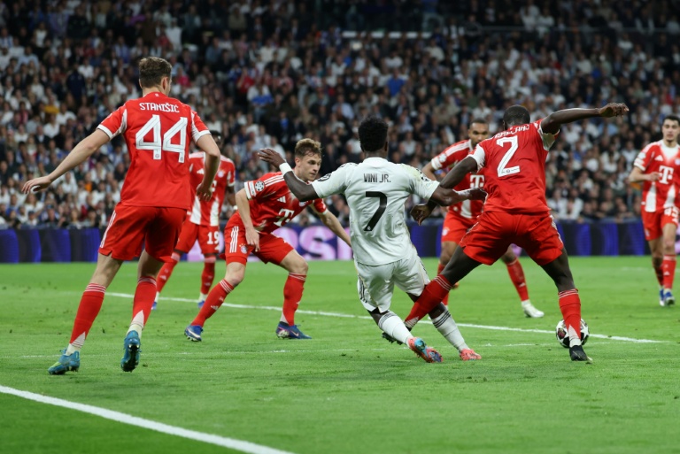 Vinicius Junior (C) au milieu de la défense munichoise lors du quart de finale aller entre le Real et le Bayern, le 7 avril 2026 au stade Santigo-Bernabéu