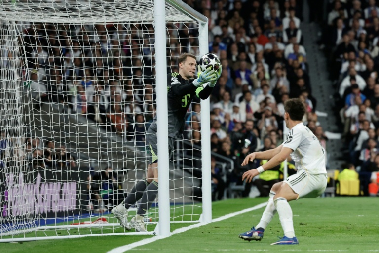Manuel Neuer (g) capte un ballon devant Arda Guler lors du quart de finale aller de Ligue des champions entre le Bayern Munich et le Real Madrid, le 7 avril 2026 à Madrid