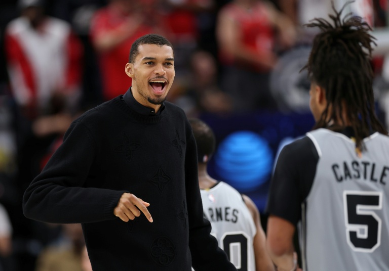 Victor Wembanyama (g), laissé au repos, félicite ses coéquipiers durant le match NBA des San Antonio Spurs contre les Los Aangeles Clippers, le 2 avril 2026 à Inglewood