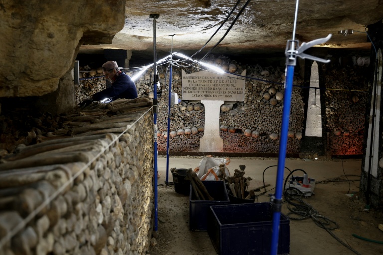 Un ouvrier construit un mur avec des ossements humains lors des travaux de restauration des Catacombes de Paris, le 24 mras 2026