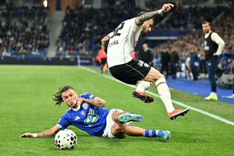 Le défenseur niçois Jonathan Clauss saute pour éviter un tacle du Strasbourgeois Diego Da Silva Moreira, lors de la demi-finale de coupe de France mercredi au Stade de la Meinau à Strasbourg.