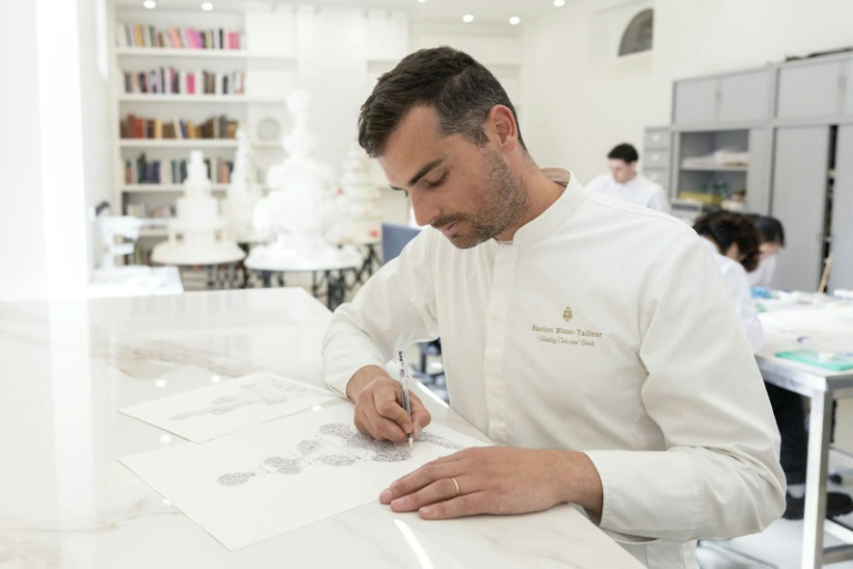 Le chef pâtissier français Bastien Blanc-Tailleur dessine le projet d'un gâteau de mariage dans son atelier de Saint-Rémy-lès-Chevreuse, dans les Yvelines, le 10 avril 2026