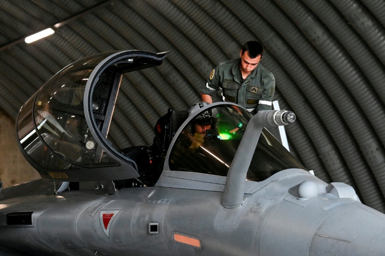 Un mécanicien aide un pilote de Rafale à s'équiper dans un abri protégé de la base aérienne d'Orange