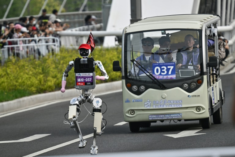 Un robot suivi par une équipe d'ingénieurs, lors du semi-marathon de Yizhuang, dans la banlieue de Pékin, le 19 avril 2026