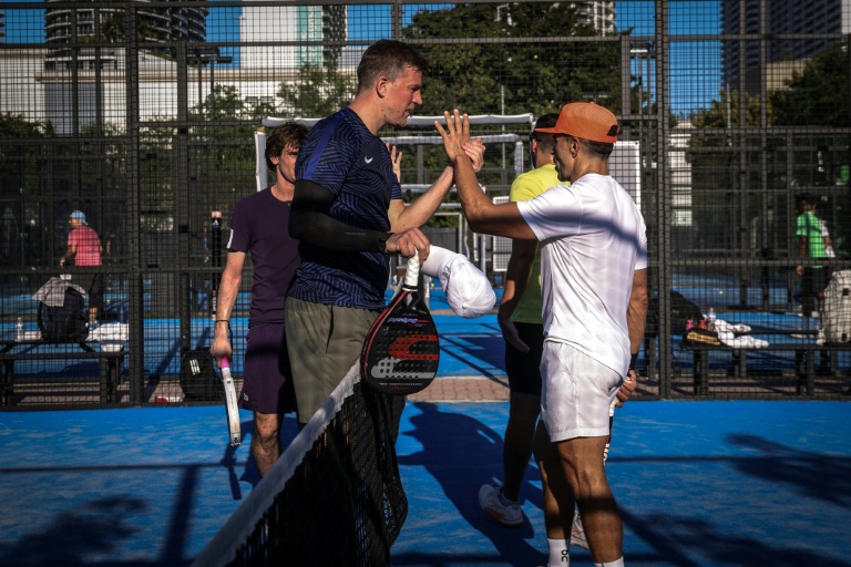 Des personnes se saluent après une partie de padel sur un court à Miami, en Floride, le 22 mars 2026