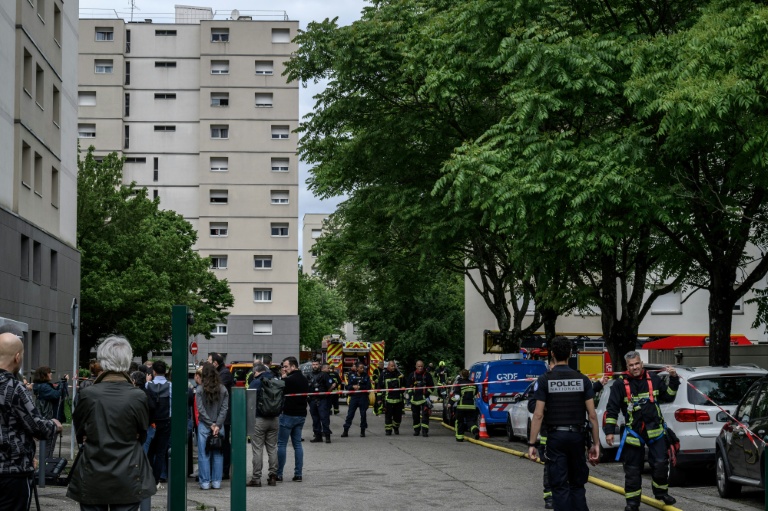 Des policiers et des pompiers sur le site d'un incendie qui s'est déclaré dans un immeuble résidentiel à Décines-Charpieu, en périphérie de Lyon, le 11 mai 2026