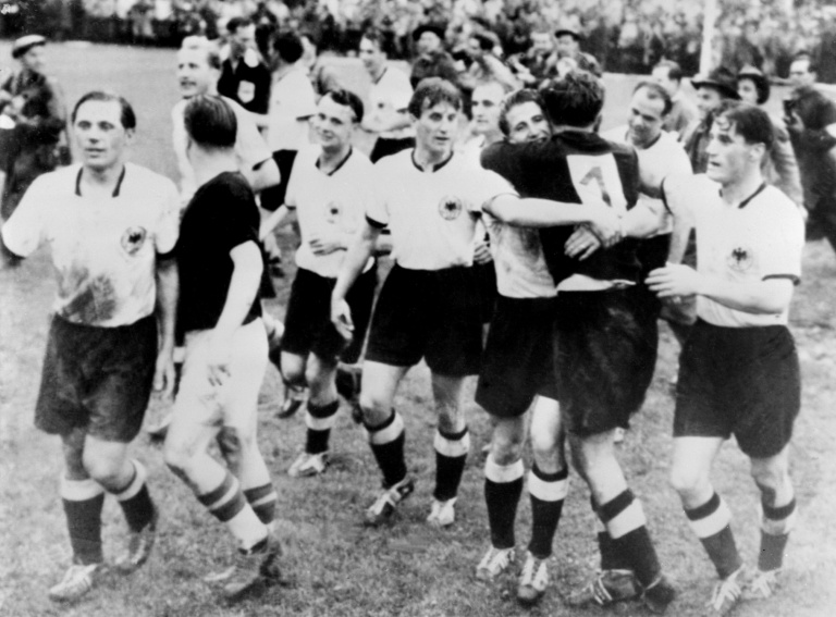 L'attaquant hongrois Ferenc Puskas (2e G, maillot noir) félicite les joueurs allemands après leur victoire face à la Hongrie (3-2) en finale de la Coupe du monde de football, le 4 juillet 1954 à Berne