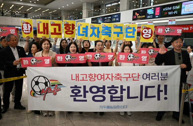 Des supporters sud-coréens brandissant des banderoles pour accueillir les footballeuses du club nord-coréen de Naegohyang, à l'aéroport international d'Incheon, le 17 mai 2026