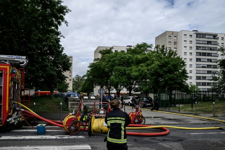 Un pompier arrive sur les lieux de l'incendie qui a fait trois morts dans un immeuble résidentiel, le 11 mai 2026 à Décines-Charpieu, près de Lyon