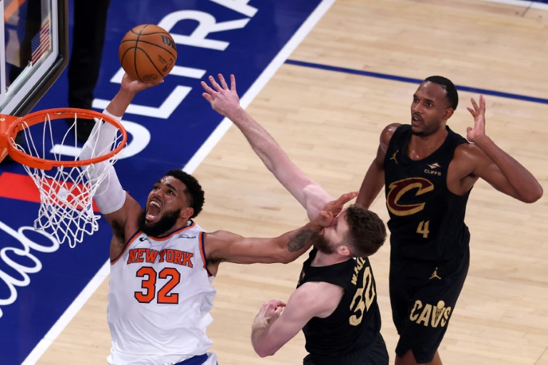 Karl-Anthony Towns va au dunk malgré la défense de Dean Wade lors de la victoire des Knicks contre Cleveland, le 19 mai 2026 à New York