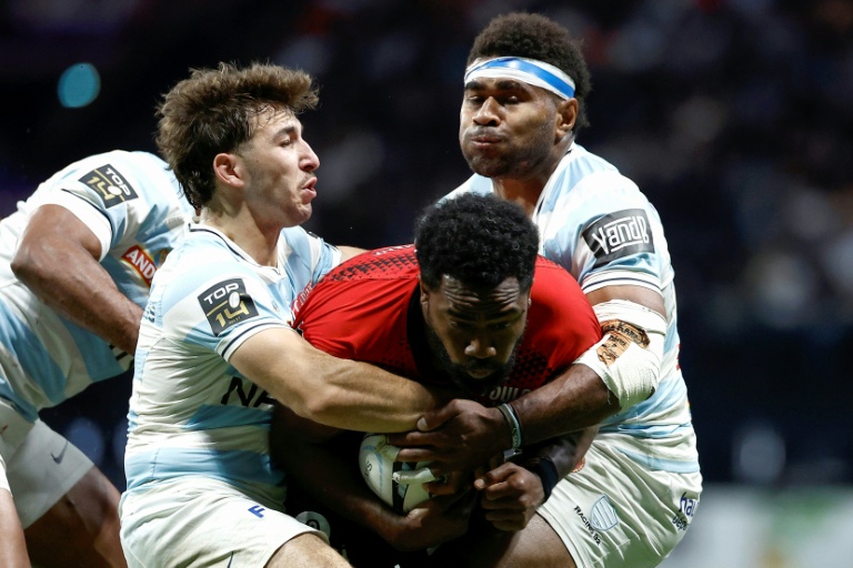 Le centre fidjien de Toulon Setariki Tuicuvu (C) est pris en tenaille par les joueurs du Racing 92 Leo Carbonneau (G) et Vinaya Habosi (D), lors de la victoire des Franciliens en Top 14, le 16 mai 2026 à La Defense Arena de Nanterre