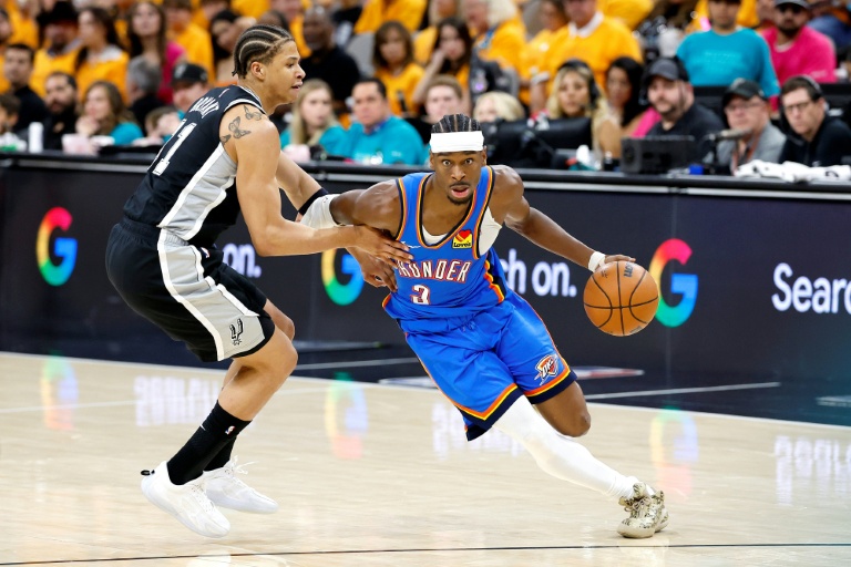 Shai Gilgeous-Alexander (d) déborde Carter Bryant lors du match 3 de la finale de conférence Ouest de NBA entre l'Oklahoma City Thunder et les San Antonio Spurs, le 22 mai 2026 à San Antonio