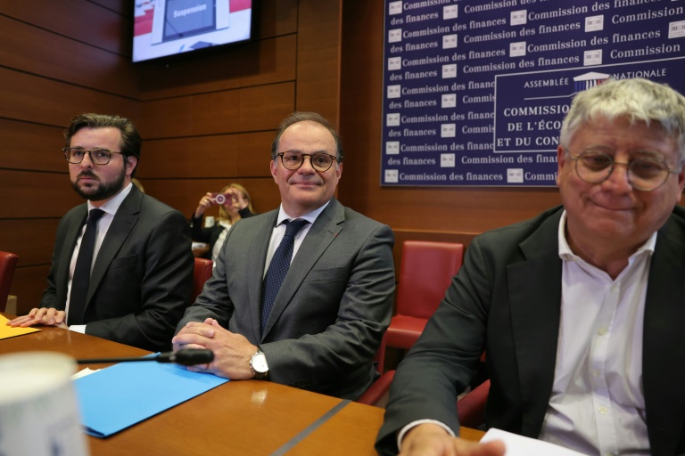 (g-d) Le député Philippe Brun (Socialistes et Apparentés), l'ancien secrétaire général de l'Elyséee et candidat au poste de gouverneur de la Banque de France, Emmanuel Moulin, et le député Eric Coquerel (LFI) assistent à une audition devant la commission des finances de l'Assemblée nationale le 20 mai 2026 à Paris