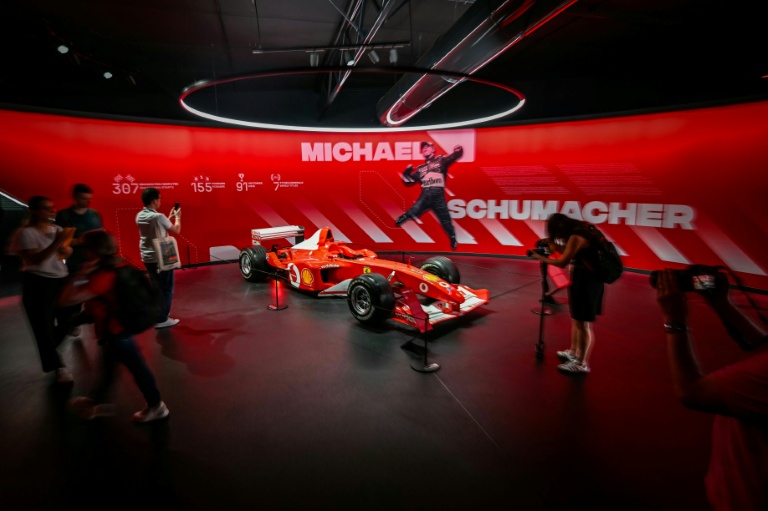 La Formule 1 Ferrari F2002 de 2002 de Michael Schumacher, exposée au Musée M24 du Mans, avec une image du pilote allemand célébrant un titre mondial.
