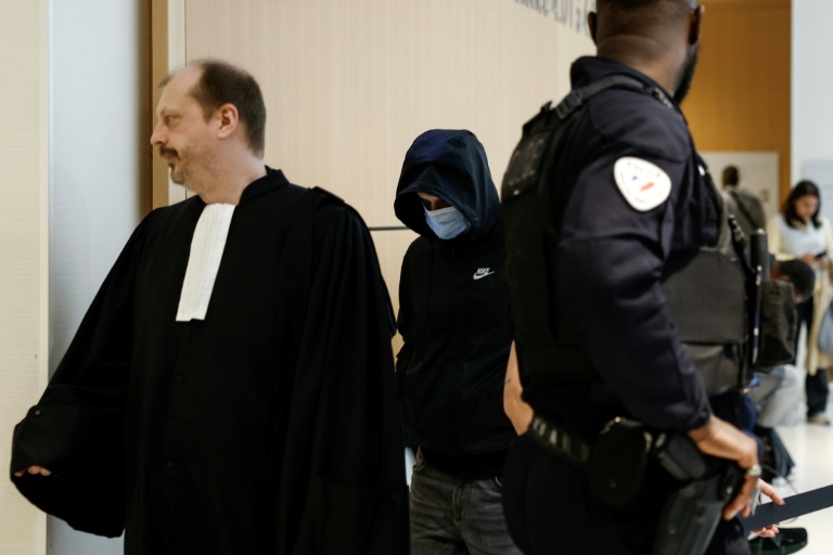 Un animateur (c) d'une école parisienne, poursuivi pour agressions sexuelles sur mineurs, arrive au tribunal de Paris, le 5 mai 2026