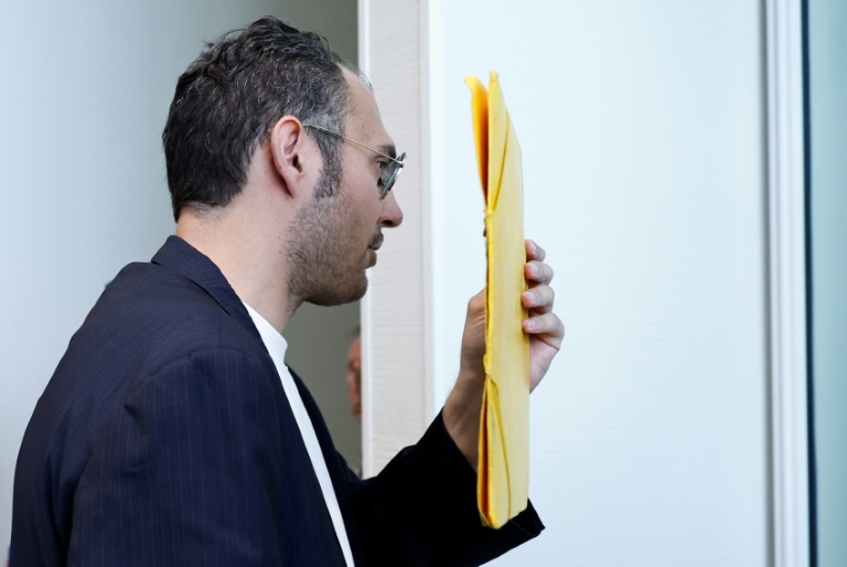 David G., animateur périscolaire, se cache le visage avec un dossier à son arrivée au tribunal où il doit être jugé pour agressions sexuelles sur neuf enfants, le 26 mai 2026