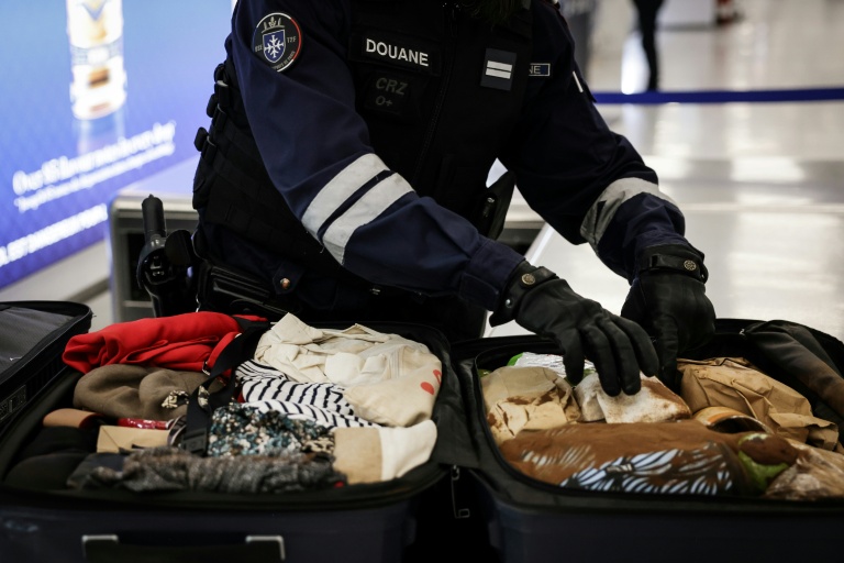 Des fouilles de bagages par des douaniers à l'aéroport Roissy-Charles-de-Gaulle au nord de Paris le 21 mars 2025