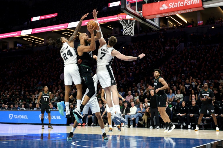 Rudy Gobert tente de s'infiltrer entre Devin Vassell et Luke Kornet lors de la victoire de San Antonio contre Minnesota, le 8 mai 2026 à Minnesota