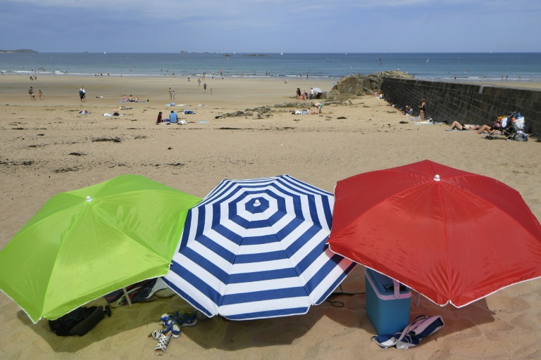 Trois parasols sur la plage de Saint-Malo, lors d'une vague de chaleur le 18 juillet 2018, en Ille-et-Vilaine