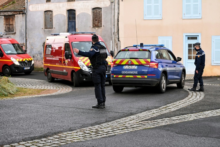 Des pompiers et des gendarmes dans le village de Saint-Just, le 23 décembre 2020, où trois gendarmes ont été tués tués par un homme armé lors d'une intervention pour violences conjugales