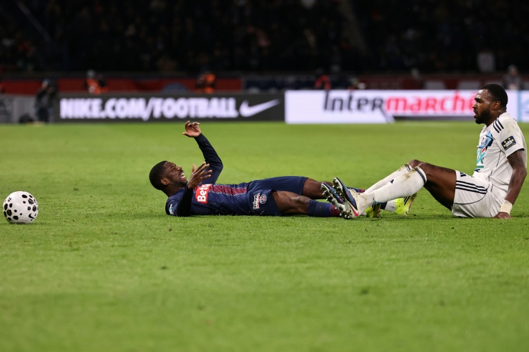 Ousmane Dembele (G) au sol face au défenseur brésilien Otavio, lors de la défaite du PSG contre le Paris FC en Coupe de France, le 12 janvier 2026 au Parc des Princes