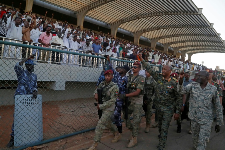 Le chef de l'armée et dirigeant de facto du pays, Abdel Fattah al-Burhane, salue les spectateurs après avoir assisté au match d'ouverture de la première ligue, le 15 mai 2026 au stade Kober à Khartoum