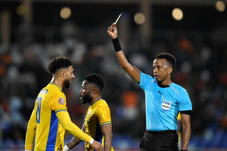 L'attaquant gabonais Denis Bouanga reçoit un carton jaune de l'arbitre somalien Omar Abdulkadir Artan lors du match de la Coupe d'Afrique des Nations (CAN) entre le Gabon et la Côte d'Ivoire à Marrakech,l e 31 décembre 2025 au Maroc