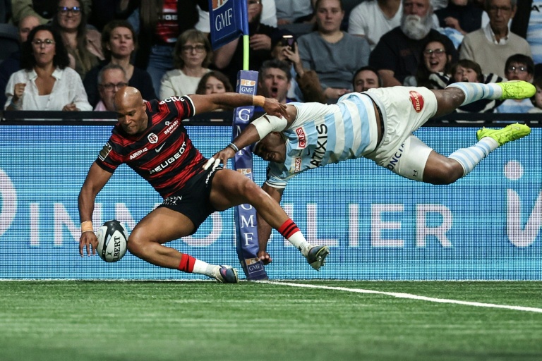 Le centre de Toulouse Teddy Thomas (g) marque un essai contre le Racing 92 lors de la dernière journée de la saison régulière de Top14, le 6 juin 2026 à Nanterre