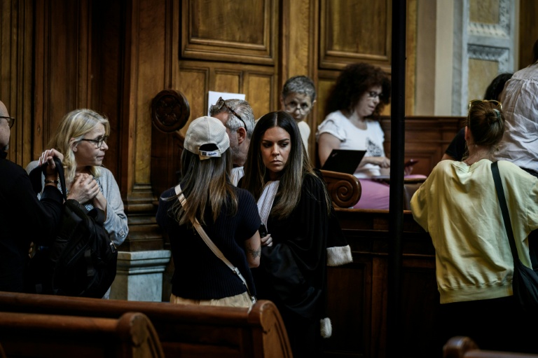 L'avocate de la partie civile Julia Studient (C) s'entretient avec sa cliente avant l'ouverture du procès à Lyon, le 11 juin 2026