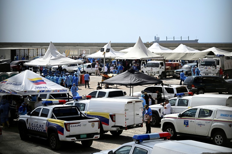 Des experts médicolégaux procèdent à l'identification de corps étendus au sol dans une morgue de fortune située dans le port de La Guaira, au Venezuela, le 29 juin 2026