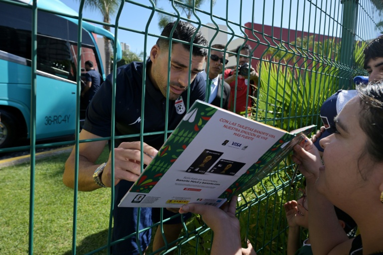 L'attaquant iranien Mehdi Taremi signe un album Panini de la Coupe du monde, pour des supporters mexicains venus l'encourager à Tijuana, le 10 juin 2026