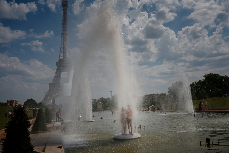Un couple se rafraîchit sous les jets d'eau du Trocadéro, à Paris, le 26 juin 2026